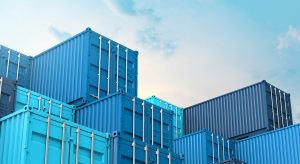 Blue shipping containers stacked in yard